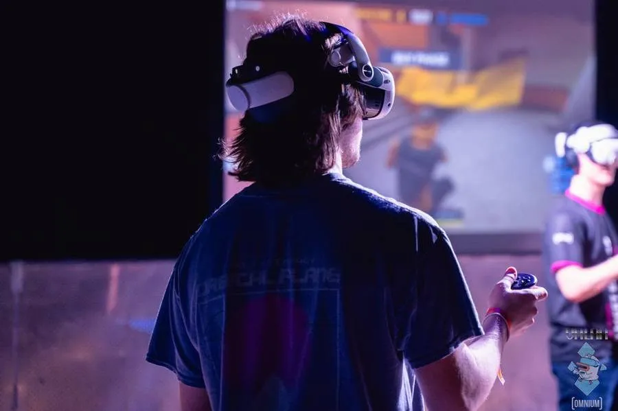 A player in a VR headset facing the big screen.