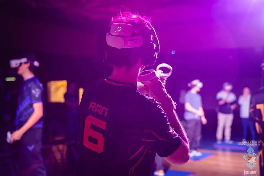 Players in numbered jerseys and headsets under purple stage light.