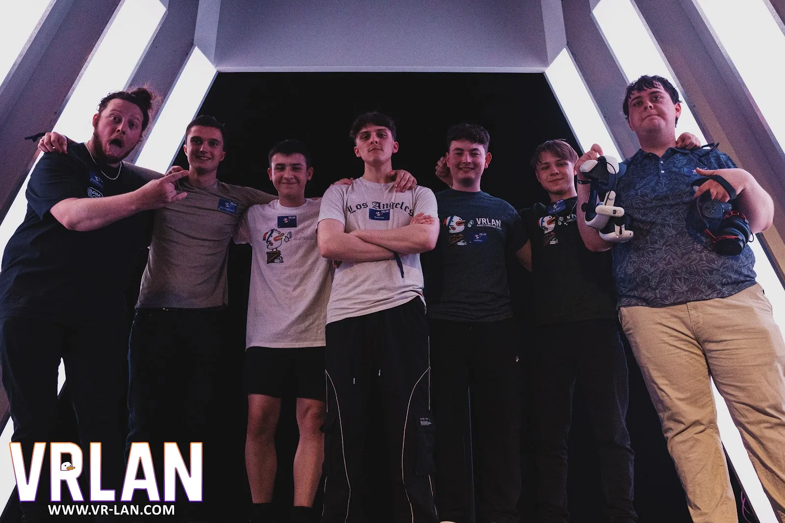 Seven players posing on stage, one holding a trophy.