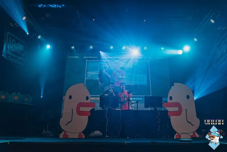 The Duckman LAN 2023 stage under a lighting rig, flanked by giant Duckman cutouts.